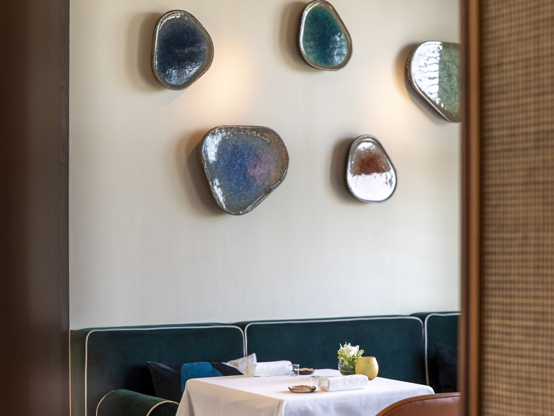 Ceramic wall pieces above a set table at Chaga